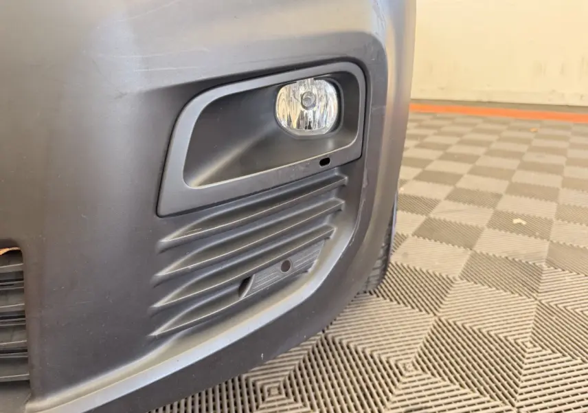 Gros plan sur le feu antibrouillard avant droit du Citroën Berlingo blanc de 2019 avec pare-chocs noir mat.