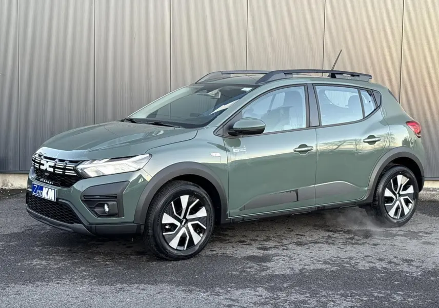 Dacia Sandero Stepway 2025 kaki lichen en 3/4 avant droit avec barres de toit et jantes spécifiques.