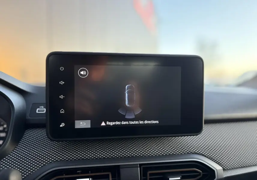 Écran tactile central affichant l'aide au stationnement sur le tableau de bord d'une Dacia Sandero Stepway 2025.