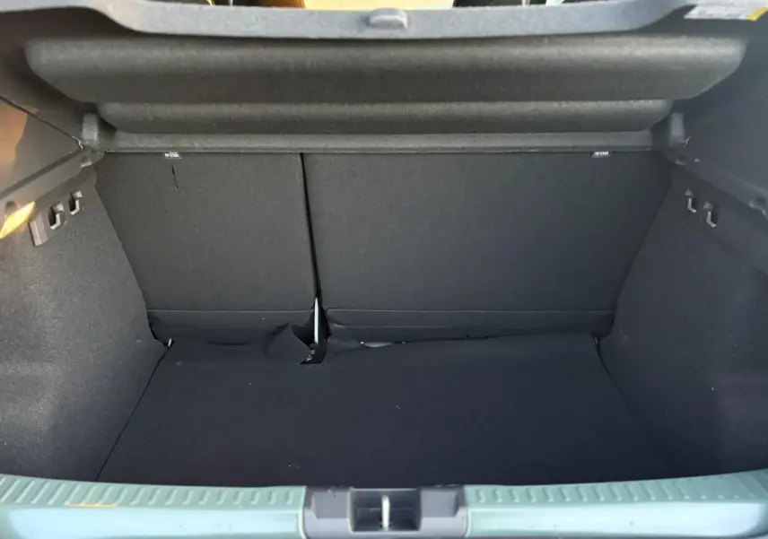Coffre ouvert d'une Dacia Sandero Stepway 2025 couleur kaki lichen, montrant l'espace de chargement intérieur.