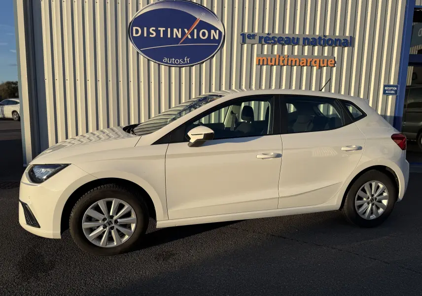 SEAT Ibiza blanc vue 3/4 avant droit, mettant en valeur ses phares LED et jantes alliage 15 pouces.