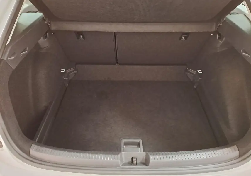 Coffre ouvert vu de l'arrière du Volkswagen Taigo blanc pur 2024, espace de chargement vide et propre.