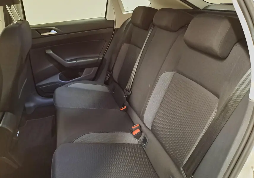 Vue intérieure côté droit des sièges arrière noirs du Volkswagen Taigo 2024, avec ceinture de sécurité et habillage de porte sombre.