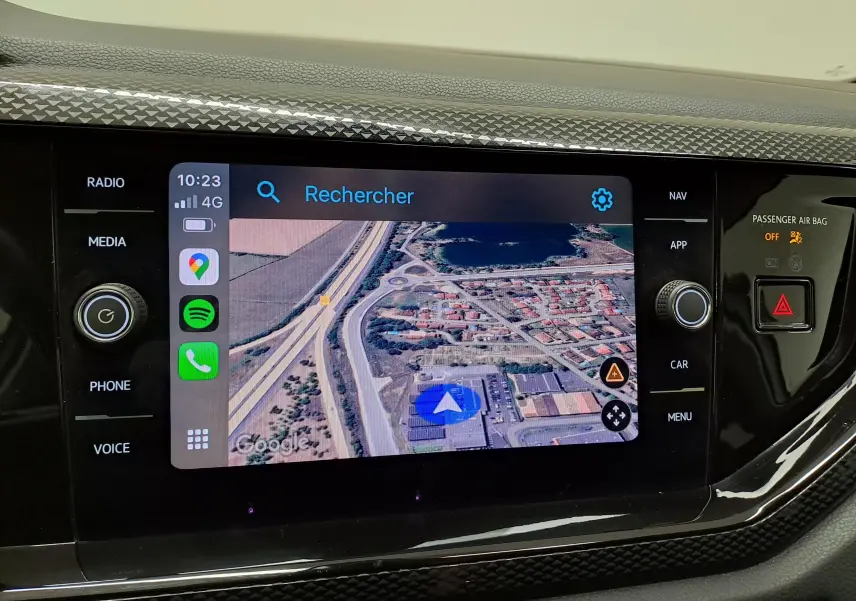 Écran tactile central du Volkswagen Taigo 2024 affichant la navigation GPS avec commandes autour, intérieur noir.