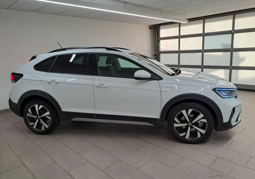 Vue de profil côté droit du Volkswagen Taigo blanc pur 2024 avec jantes alliage 17 pouces et projecteurs antibrouillard.