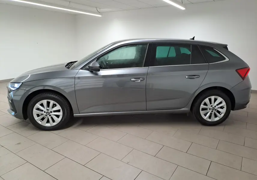 Vue de profil côté gauche d'une Skoda Scala 2025 gris graphite métallisé avec jantes alliage et caméra de recul.