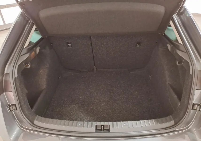 Coffre ouvert vu de l'arrière d'une Skoda Scala 2025 gris graphite, montrant l'espace de chargement vide.
