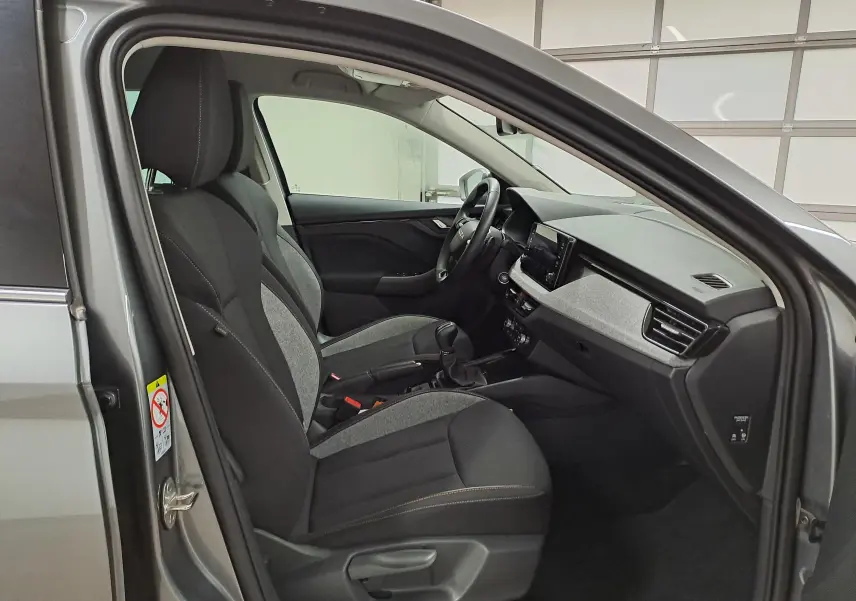 Vue intérieure côté conducteur de la Skoda Scala 2025 gris graphite, montrant sièges tissu bicolore et tableau de bord moderne.
