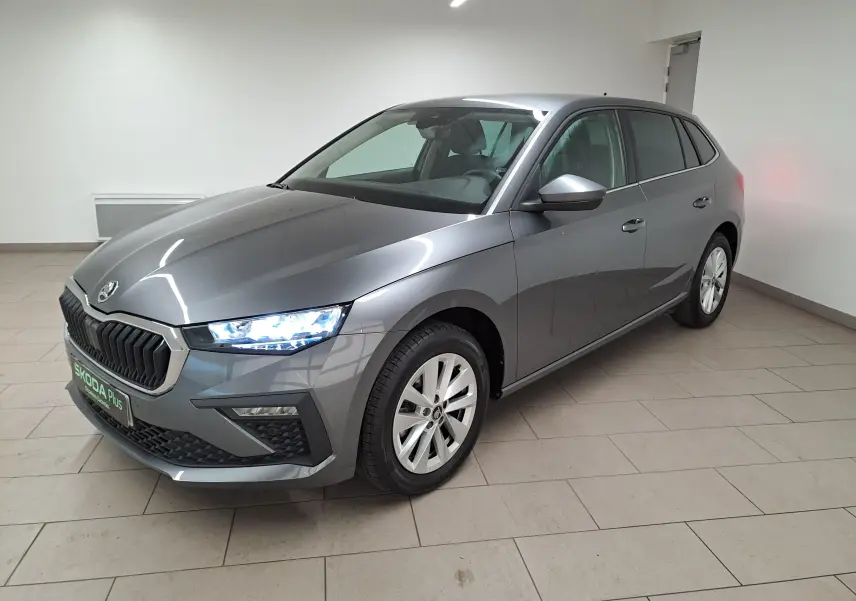 Vue 3/4 avant droite d'une Skoda Scala 2025 gris graphite métallisé avec phares allumés en intérieur.