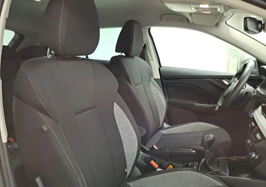 Vue intérieure côté droit des sièges avant en tissu gris et noir d'une Skoda Scala 2025 avec volant et levier de vitesse visibles.