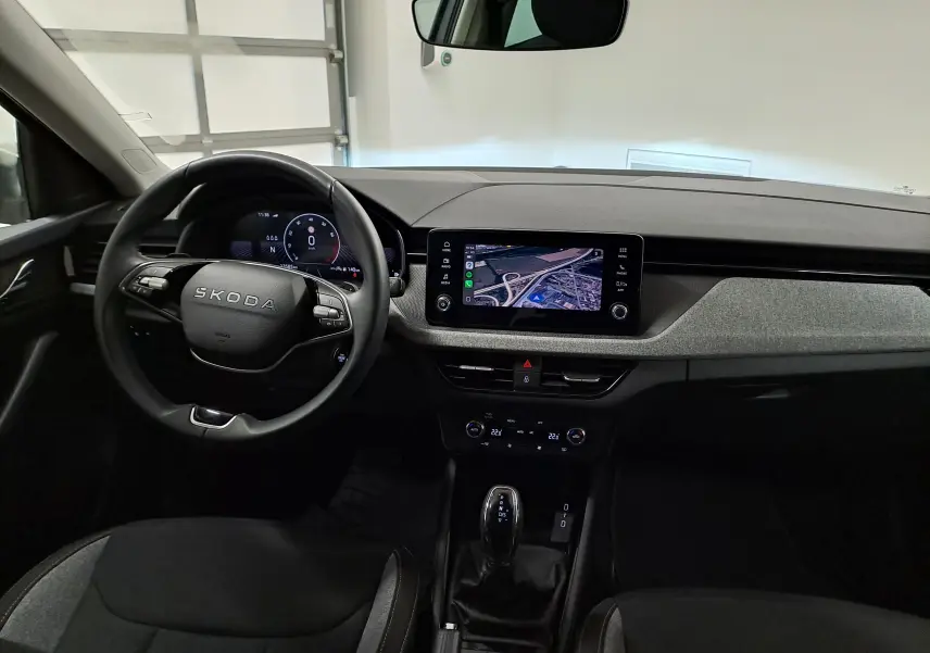 Intérieur de la Skoda Scala 2025 vu de face, tableau de bord avec écran tactile affichant la caméra de recul.