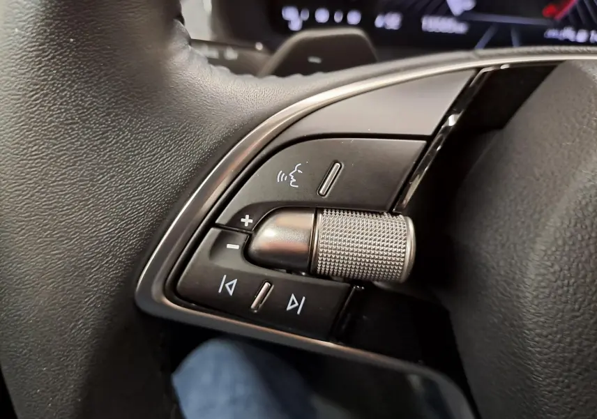 Gros plan sur les commandes vocales et multimédia au volant d’un Skoda Scala gris graphite 2025.