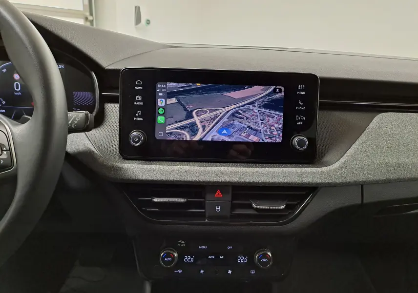 Vue intérieure du tableau de bord de la Skoda Scala 2025 avec écran tactile affichant la caméra de recul et commandes climatisation.