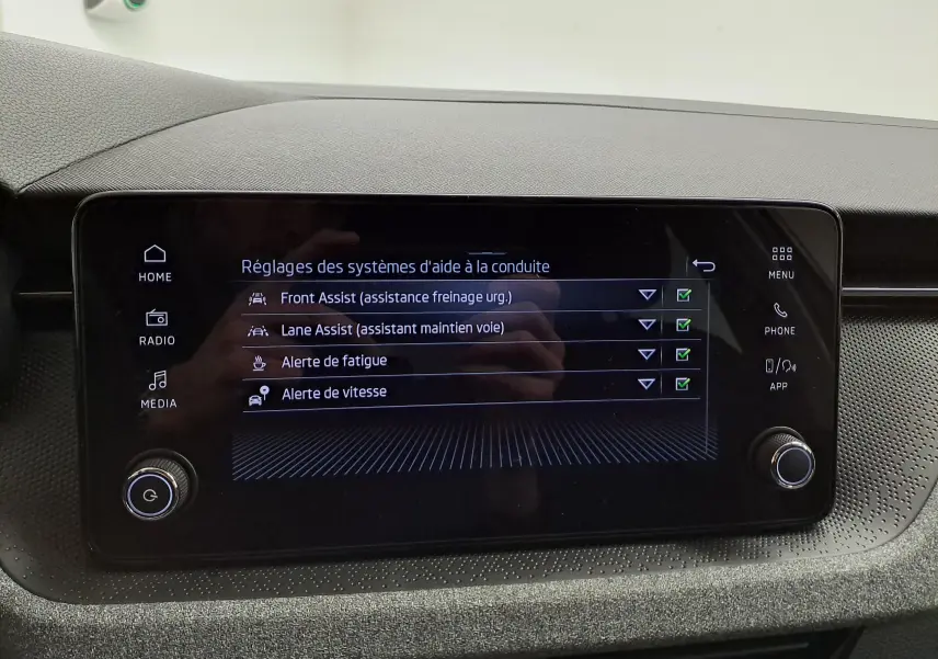 Écran tactile central du Skoda Scala 2025 affichant les réglages des aides à la conduite dans un intérieur sobre.
