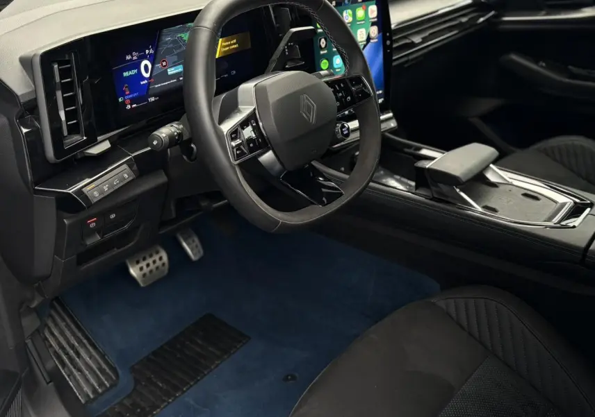 Vue intérieure côté conducteur du Renault Rafale 2025, volant Alcantara, écran tactile et sellerie noire avec surpiqûres tricolores.