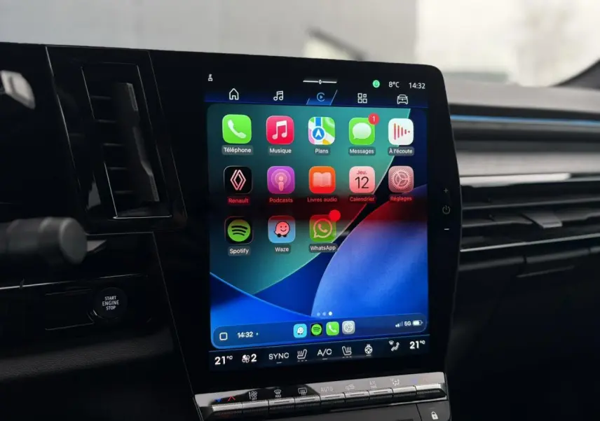Écran tactile central affichant l’interface Apple CarPlay dans l’habitacle sombre du Renault Rafale 4x4 Bleu Sommet.