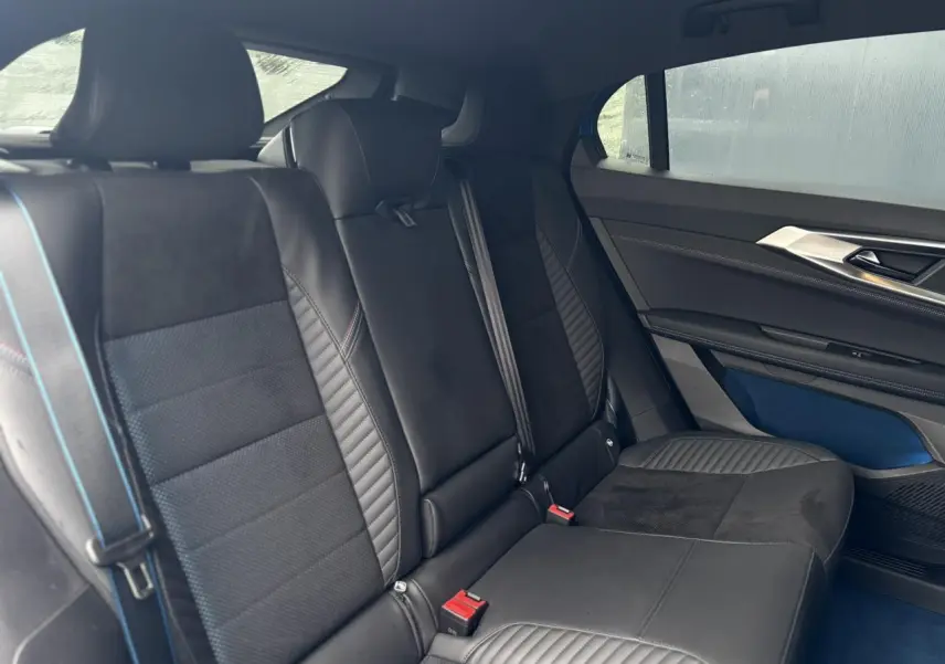 Vue intérieure arrière côté droit du Renault Rafale 2025, sièges en Alcantara noir avec surpiqûres bleues et inserts textiles.