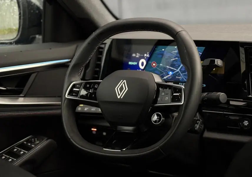 Vue intérieure centrée sur le volant noir de la Renault Rafale 2025 avec tableau de bord numérique et commandes intégrées.