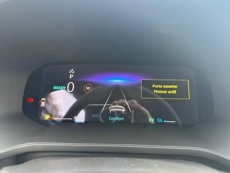 Affichage numérique du tableau de bord du Renault Captur 1.8 E-Tech hybride 2026, indiquant porte ouverte et mode confort.