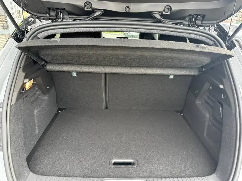 Vue arrière du coffre ouvert du Renault Captur 1.8 E-Tech hybride 2026 en Gris Rafale/Noir Etoilé, espace de chargement vide.