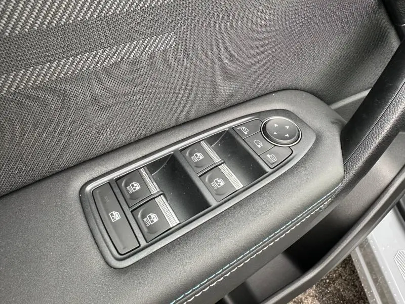 Gros plan sur les commandes des vitres électriques côté conducteur du Renault Captur 2026 Gris Rafale/Noir Étoilé.