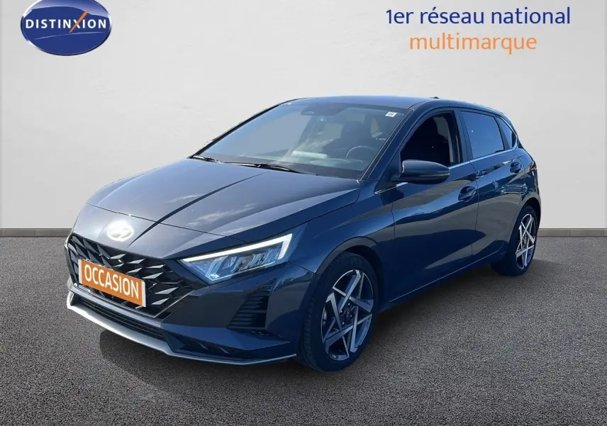 Hyundai i20 gris Aurora métal vue 3/4 avant droit avec jantes alliage et calandre noire distinctive.