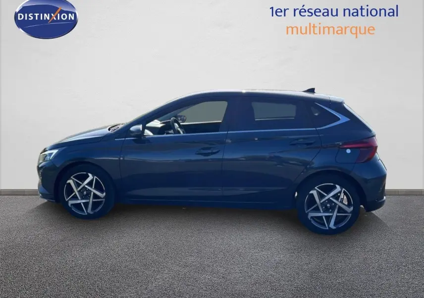 Profil latéral droit d'une Hyundai i20 2025 gris Aurora metal avec jantes alliage et vitres teintées.