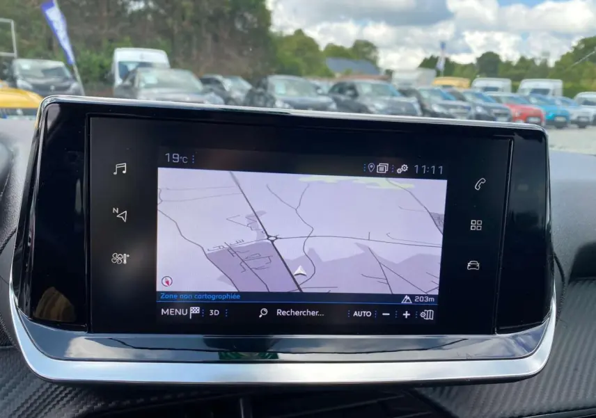 Écran tactile 7 pouces affichant la navigation 3D dans l’habitacle d’une Peugeot 208 noire de 2021.