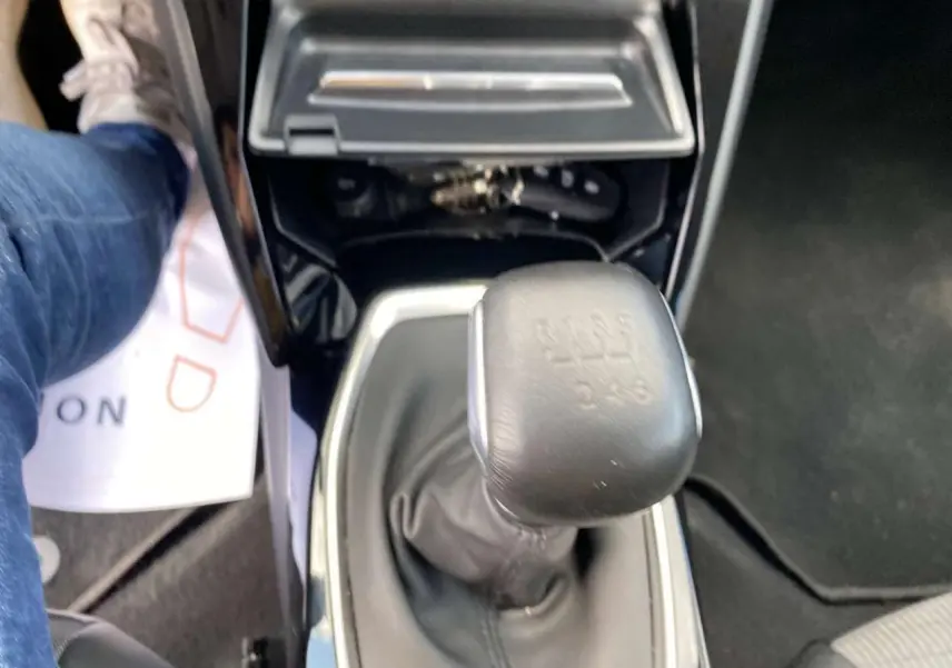 Vue rapprochée du levier de vitesses manuel noir de la Peugeot 208 2021, avec console centrale brillante autour.