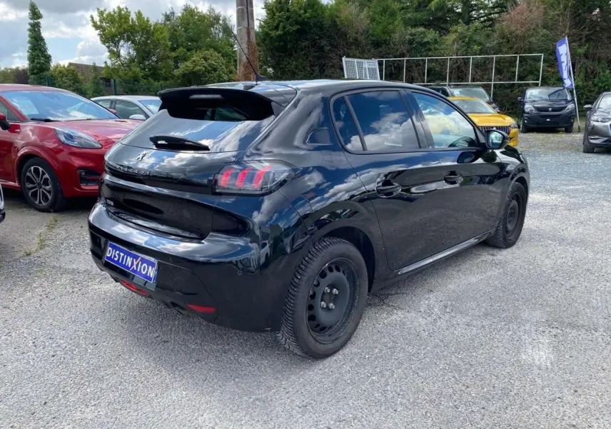 Vue 3/4 arrière droite d'une Peugeot 208 noire 2021 avec jantes tôles et feux arrière à griffes rouges.