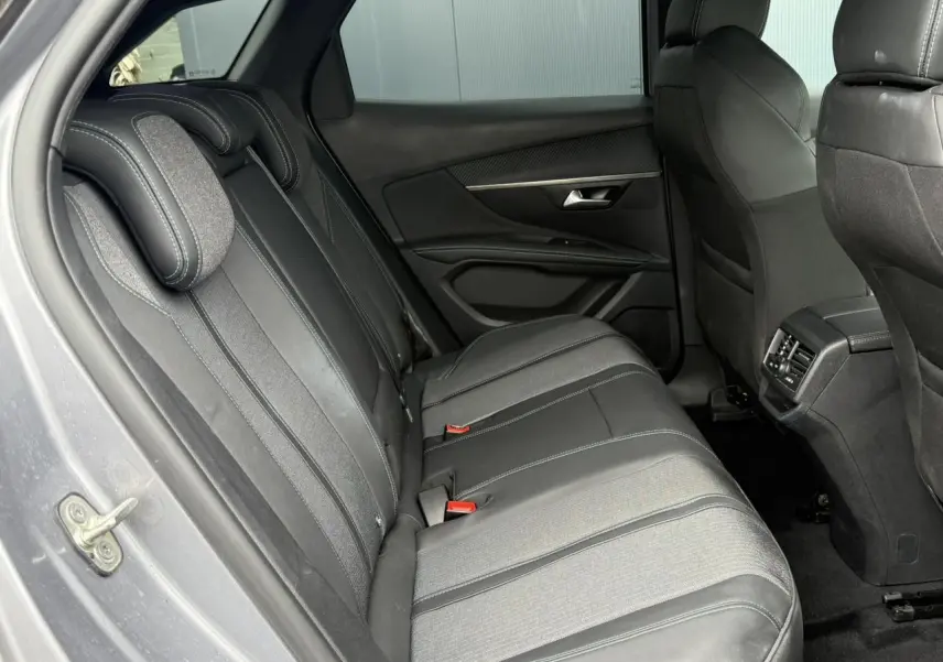 Vue intérieure arrière côté gauche du Peugeot 3008 2024 gris Artense, sièges en cuir et tissu noir avec surpiqûres contrastées.