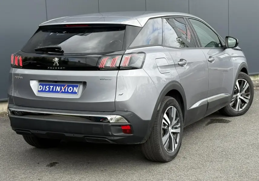 Vue 3/4 arrière droite d’un Peugeot 3008 gris Artense avec jantes alliage bi-ton et badge Hybrid visible sur l’aile.