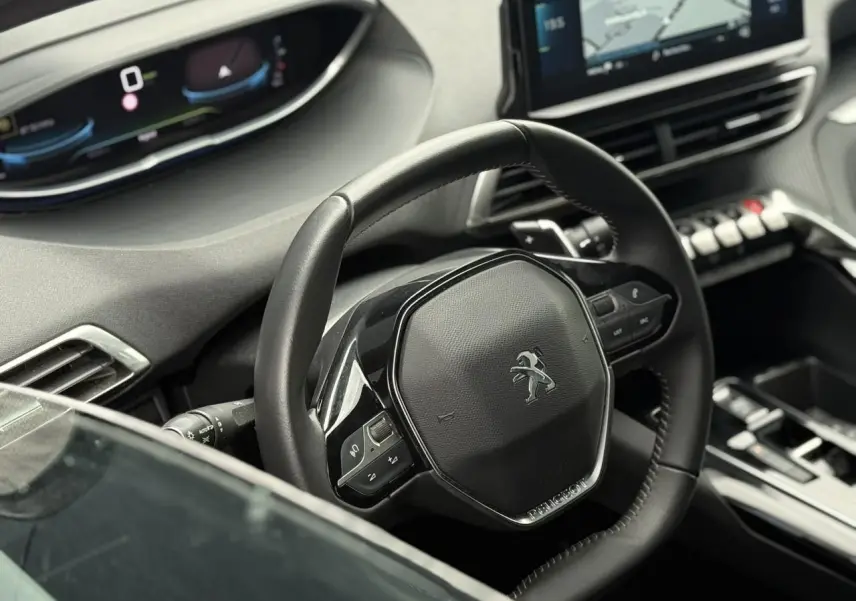 Vue intérieure du volant compact Peugeot 3008 2024 avec tableau de bord numérique et écran tactile central.