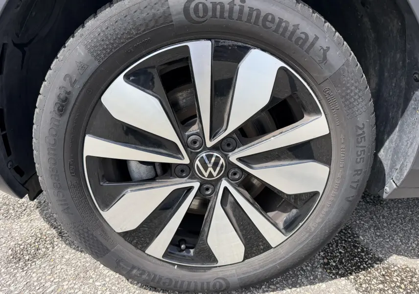 Gros plan sur la jante alliage bicolore du côté avant droit du Volkswagen T-Roc gris, avec pneu Continental visible.