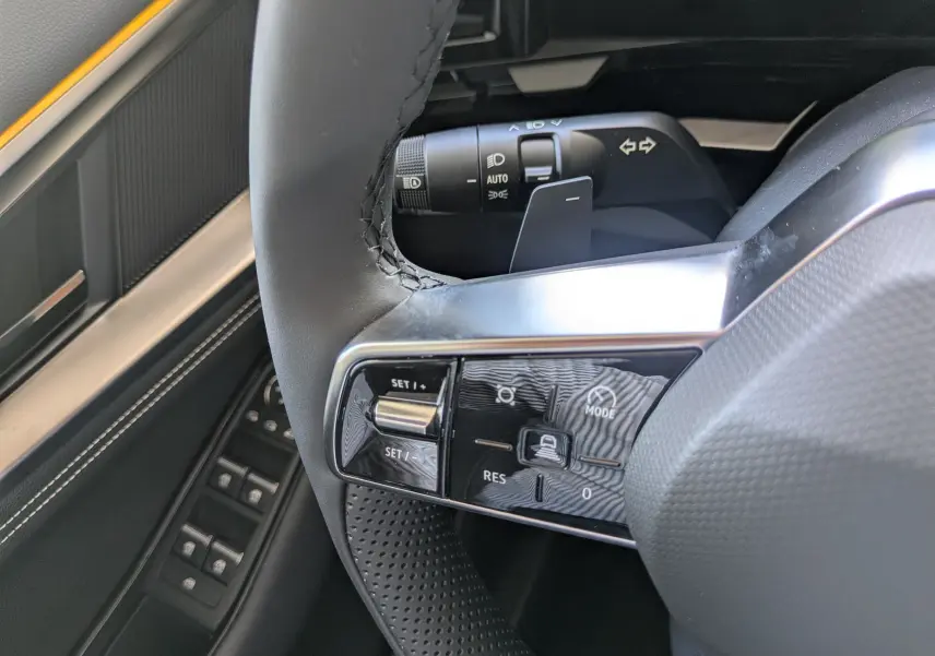 Gros plan sur les commandes de la planche de bord du Renault Austral E-Tech 200, boutons de parking et assistance visibles.