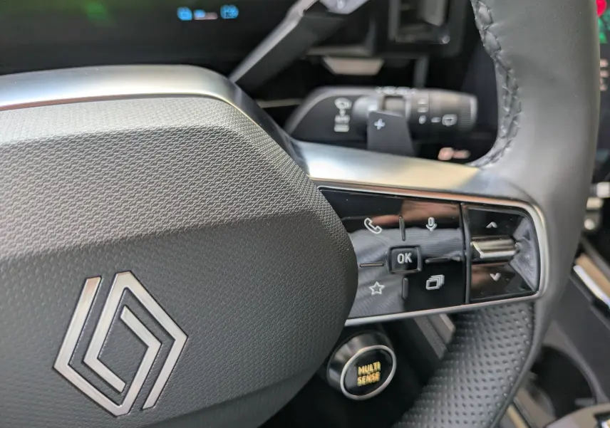 Gros plan sur les commandes gauche du volant du Renault Austral E-Tech 200 gris schiste, avec détails des boutons et levier.