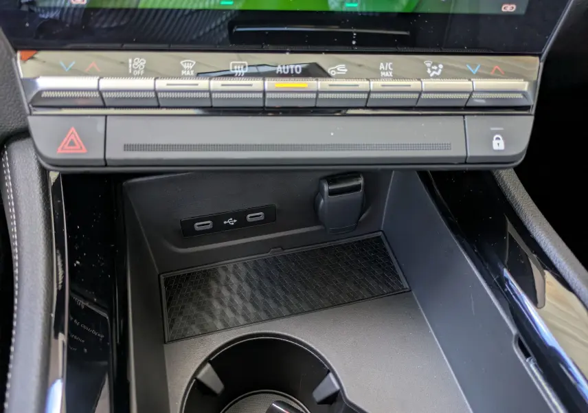 Vue plongeante sur la console centrale du Renault Austral E-Tech 200, avec chargeur sans fil et accoudoir gris.