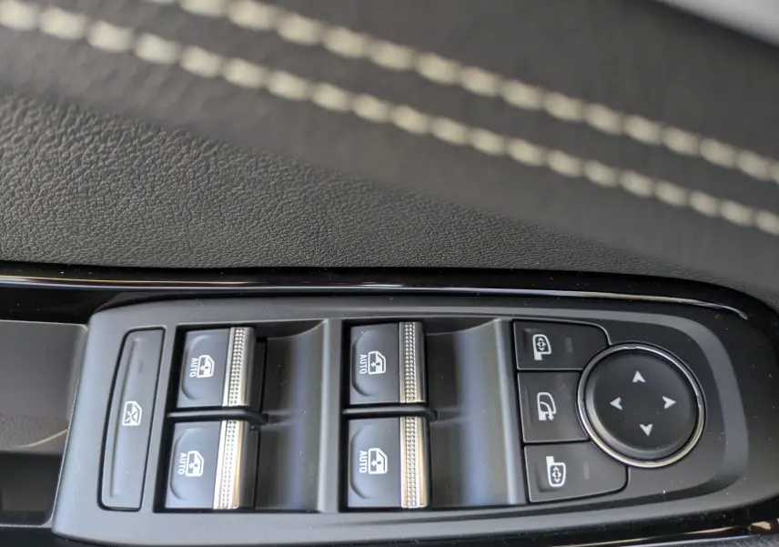 Gros plan sur les commandes des vitres électriques et rétroviseurs du Renault Austral E-Tech 200 Esprit Techno, intérieur noir.