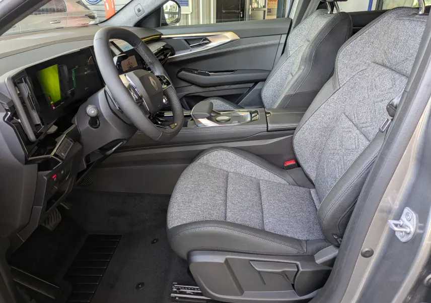 Vue intérieure du tableau de bord du Renault Austral E-Tech 200, avec volant multifonction et écran tactile vertical.