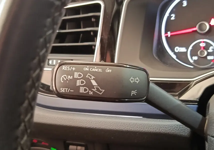 Gros plan sur la manette de commande multifonctions à gauche du volant dans le tableau de bord d'une Volkswagen Polo 1.0 TSI 95 United.