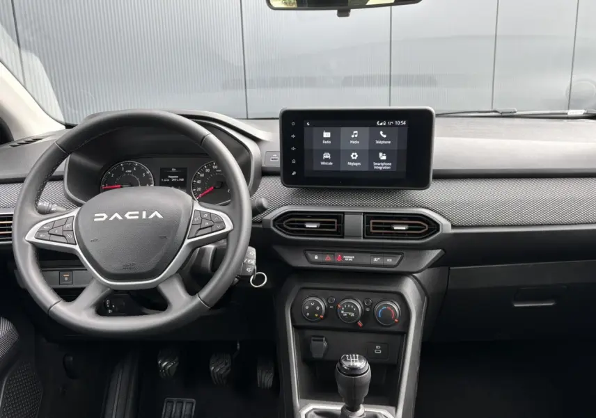 Vue intérieure du tableau de bord et volant gris de la Dacia Sandero Stepway 2025 avec écran tactile central et boîte manuelle.