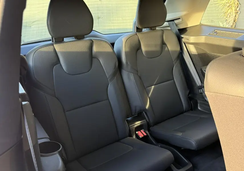 Vue intérieure sur les sièges noirs de la troisième rangée du Volvo XC90 T8 AWD 2024 en lumière naturelle.