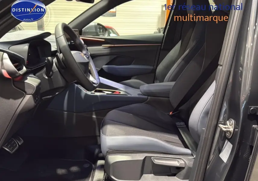 Intérieur avant droit de la CUPRA TERRAMAR gris 2025 avec sièges sport bicolores et volant cuir multifonction.