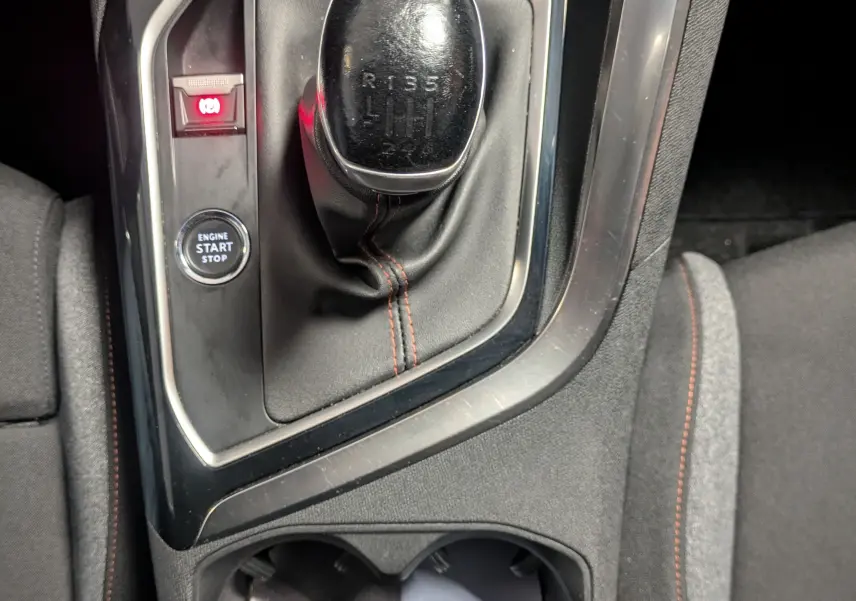 Gros plan sur le levier de vitesse manuel et le bouton start/stop dans l’habitacle noir du Peugeot 3008 gris Arthense.