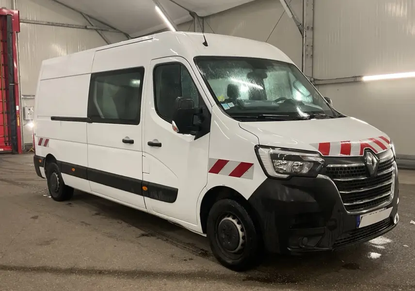Renault Master cabine approfondie blanc en 3/4 avant droit avec bandes rouges de signalisation sur capot et ailes.
