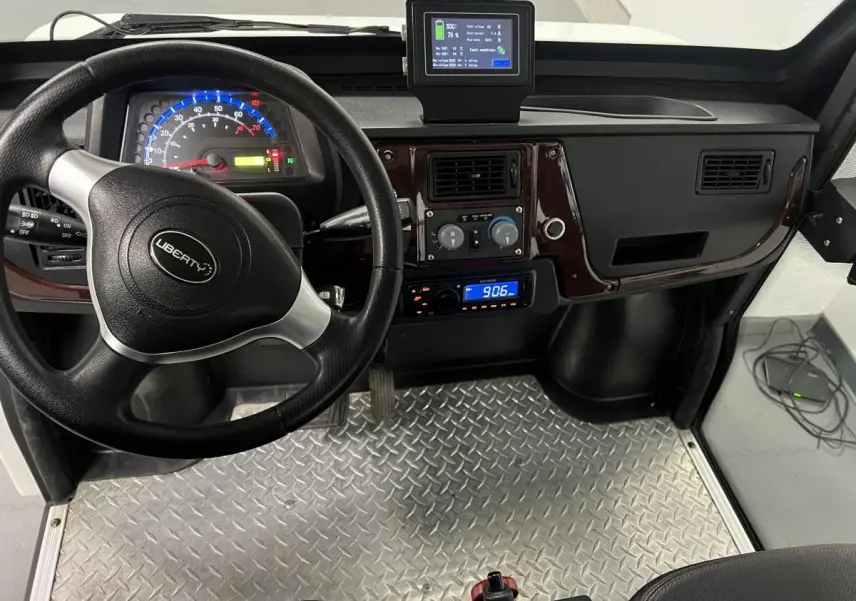 Vue intérieure frontale du tableau de bord du Liberty L7e H2 Cargo blanc, volant trois branches et revêtement sol aluminium.