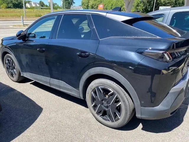 Vue côté gauche arrière du Peugeot 3008 noir 2024 avec jantes noires et toit panoramique visible.