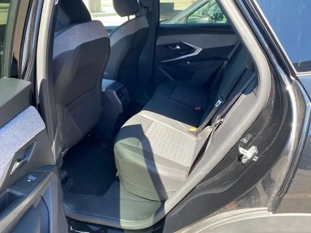 Vue intérieure côté droit arrière du Peugeot 3008 noir 2024, montrant les sièges arrière en tissu bicolore gris et noir.