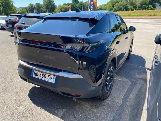 Vue 3/4 arrière droite d’un Peugeot 3008 noir 2024 hybride, avec feux arrière LED et jantes bi-ton visibles.