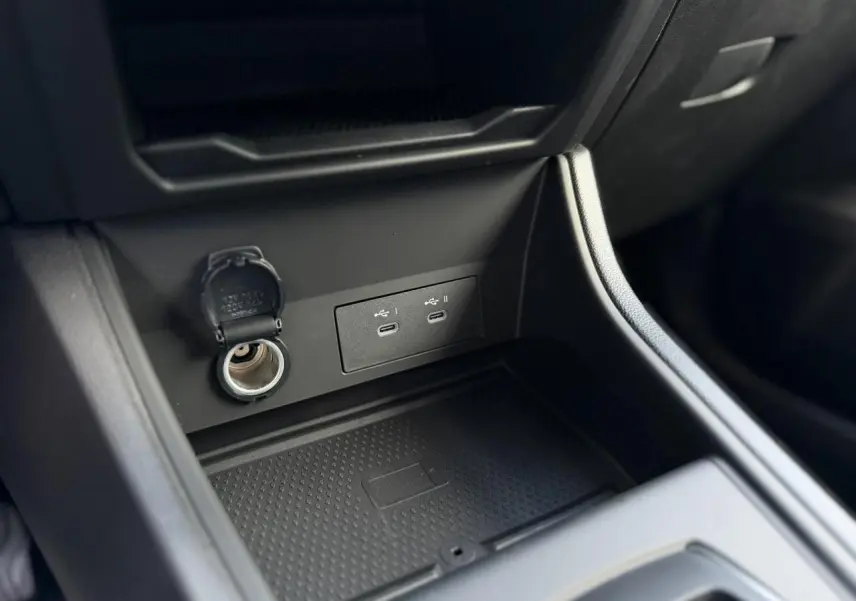 Vue rapprochée de la console centrale noire du Renault Captur 2026, avec prises USB-C et prise 12V ouvertes.